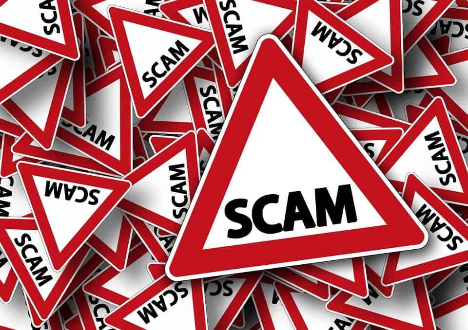 Scattered stacks of triangles with outside outline being red and white inside, with black lettering in center that reads scam