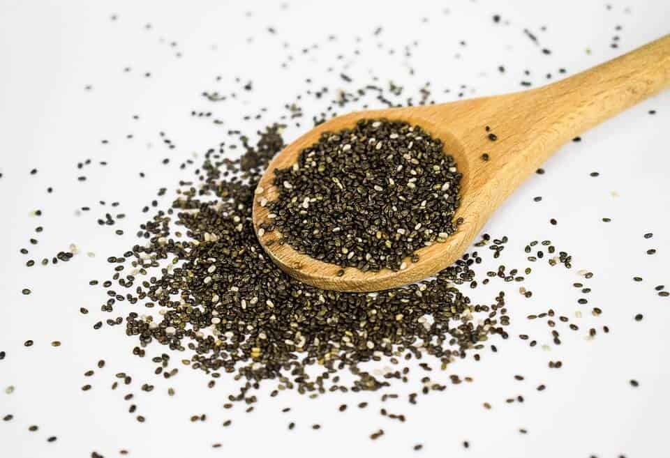 unorganized amount of chia seeds on top of wooden spoon