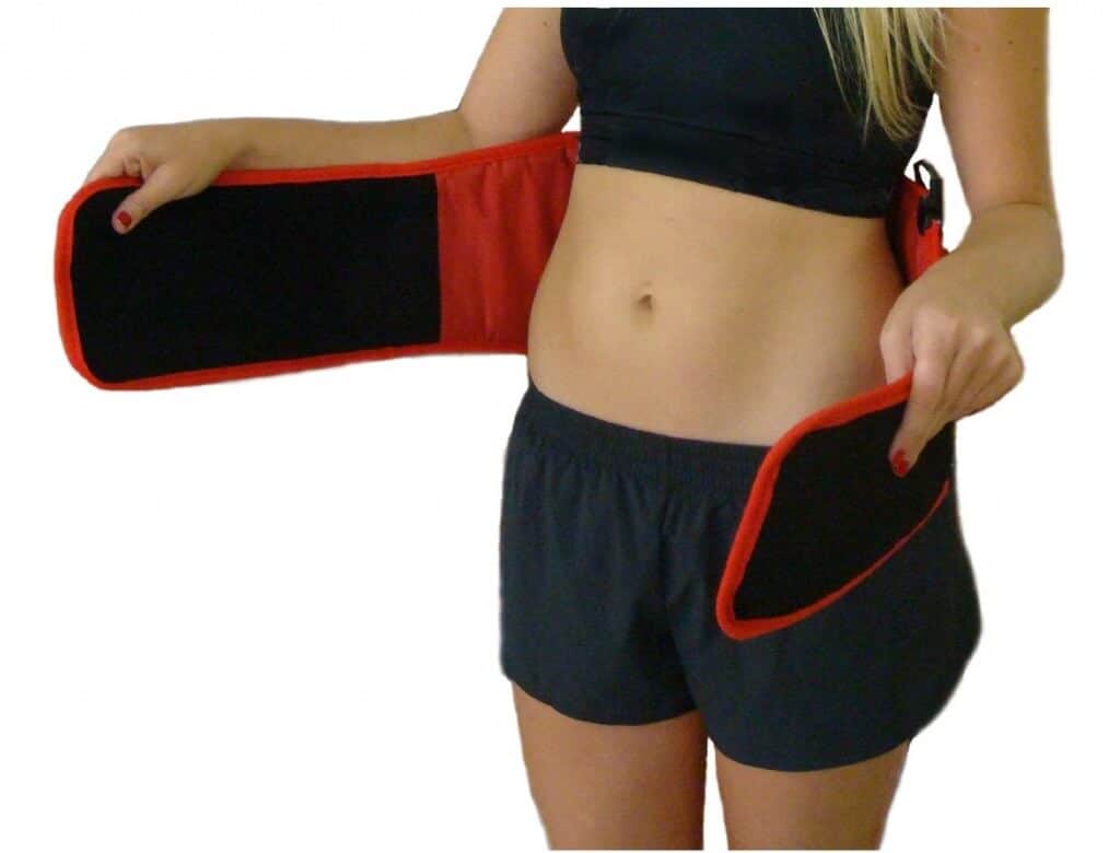 Blonde women in athletic gear adjusting her black and red weight loss belt